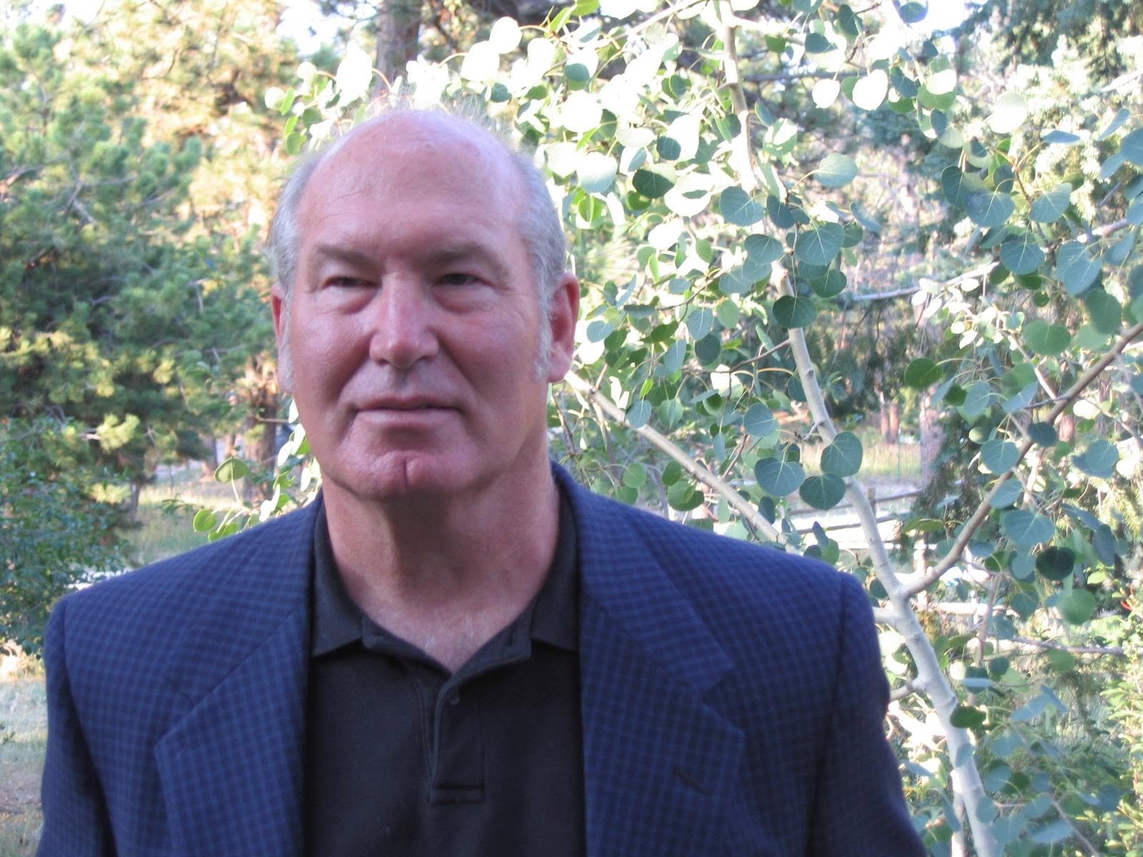 Thomas J. “Tom” Owen standing among aspens and pines