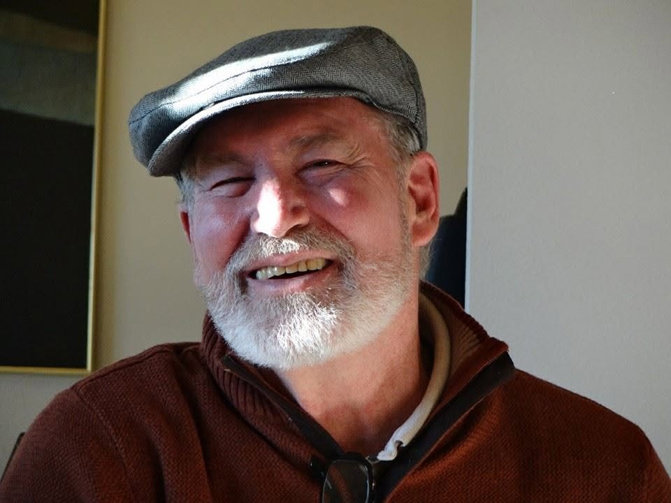 Thomas J. “Tom” Owen, smiling, in a flat cap