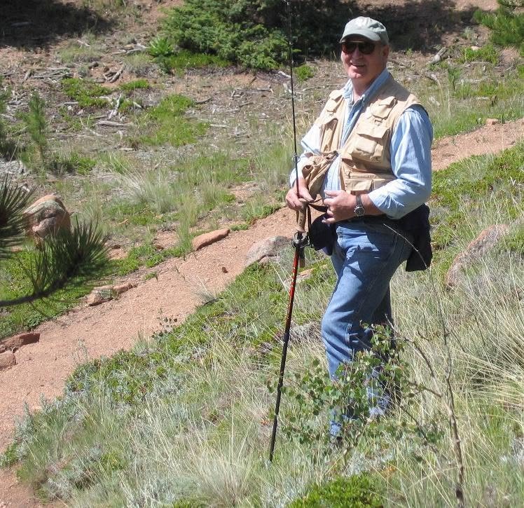Thomas J. “Tom” Owen on a hillside with a fly rod